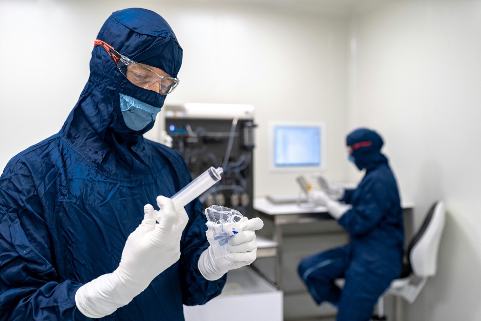 Cleanroom workers in protective gear for Incure CDM™ UV conveyor medical device bonding production
