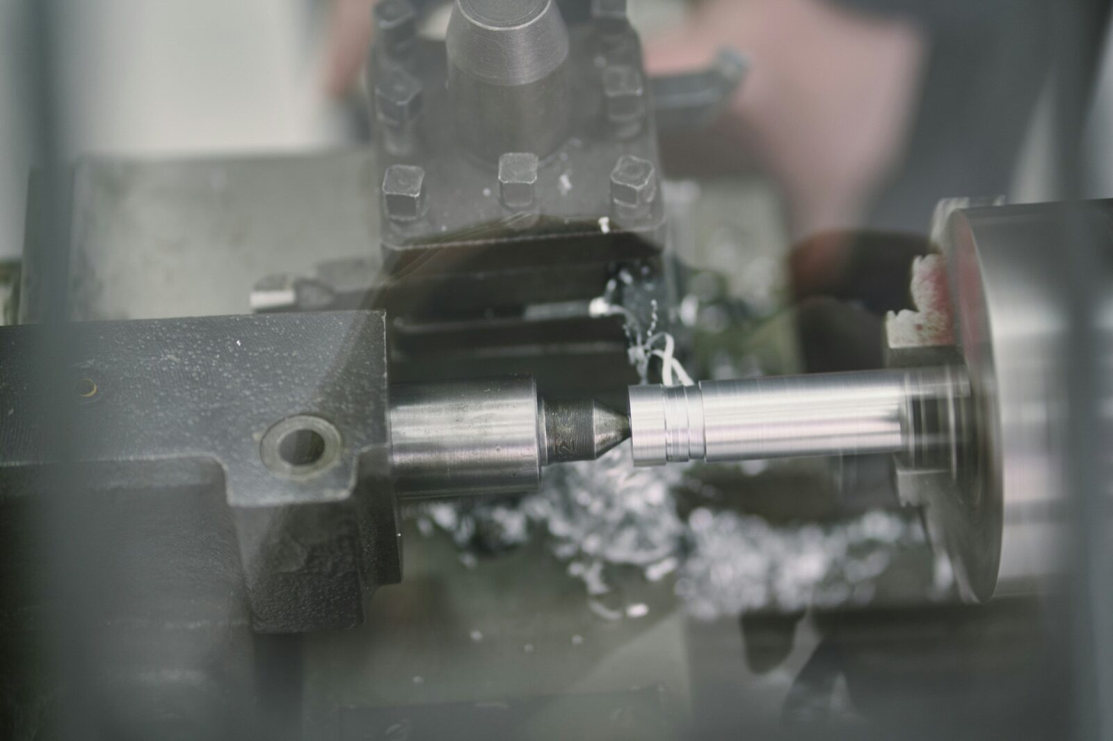 Metal lathe turning cylindrical rod in industrial workshop for Pyra-Sil™ machining and sandblasting masking