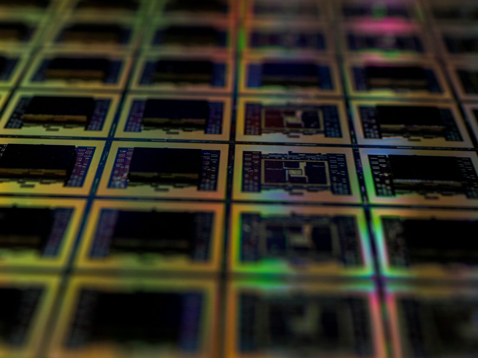 Silicon wafer with iridescent die array close-up for Incure Sniper™ dispensing needle semiconductor underfill epoxy