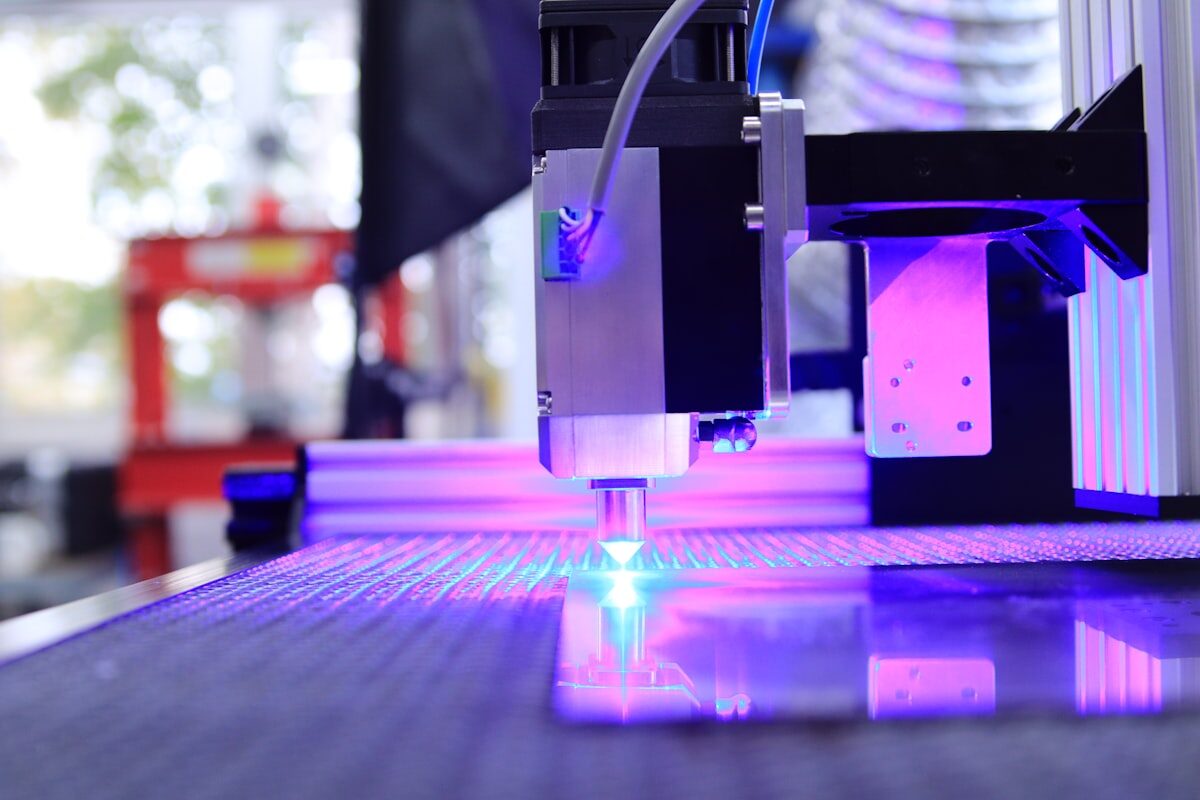 Purple UV laser light from CNC optical system for Uni-Seal™ UV gasket dam-and-fill and active alignment fixturing